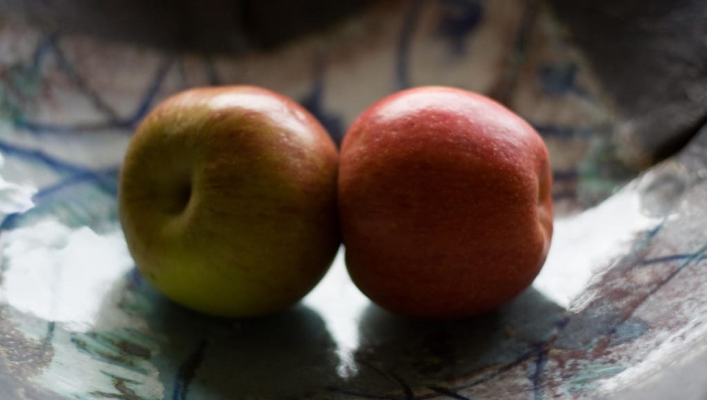 Die Alte durch die Neue ersetzen - Zwei Äpfel in einer Obstschale